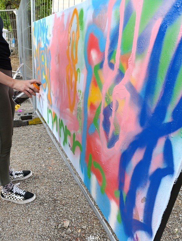Wand wird mit Farbe besprüht