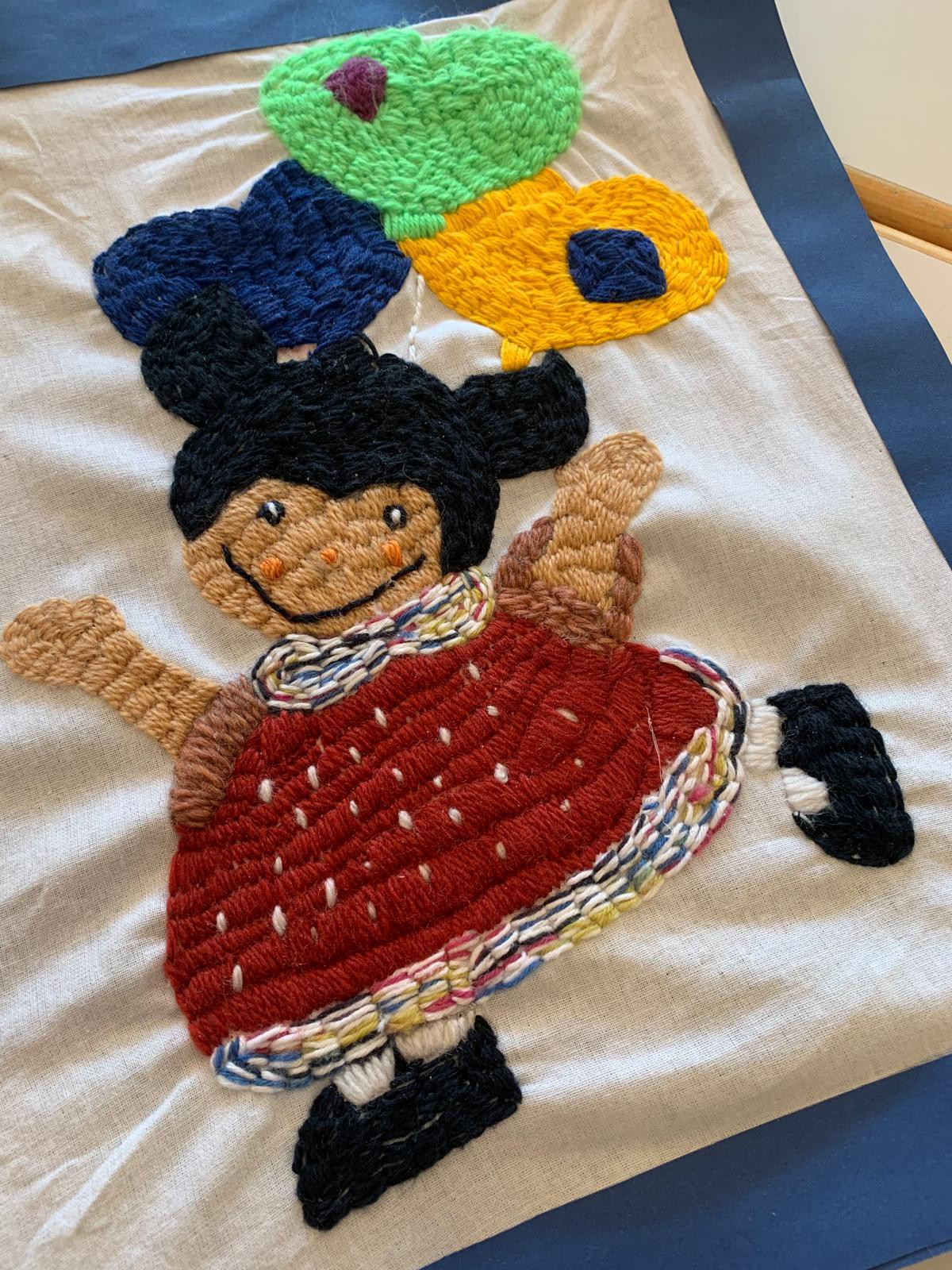 Besticktes Bild mit Puppenmuster