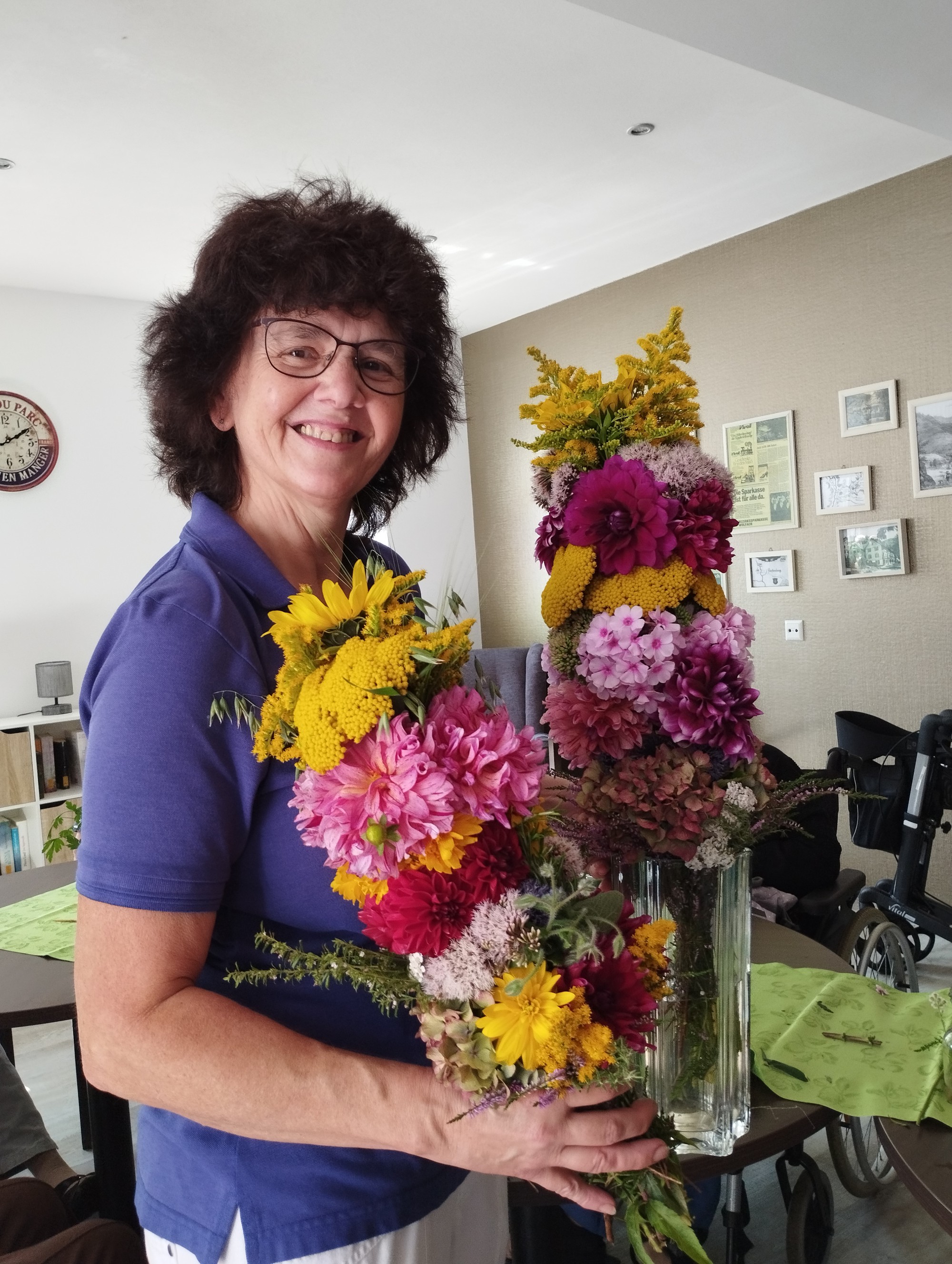 Mitarbeiterin mit selbstgebasteltem Kräuterbüschel