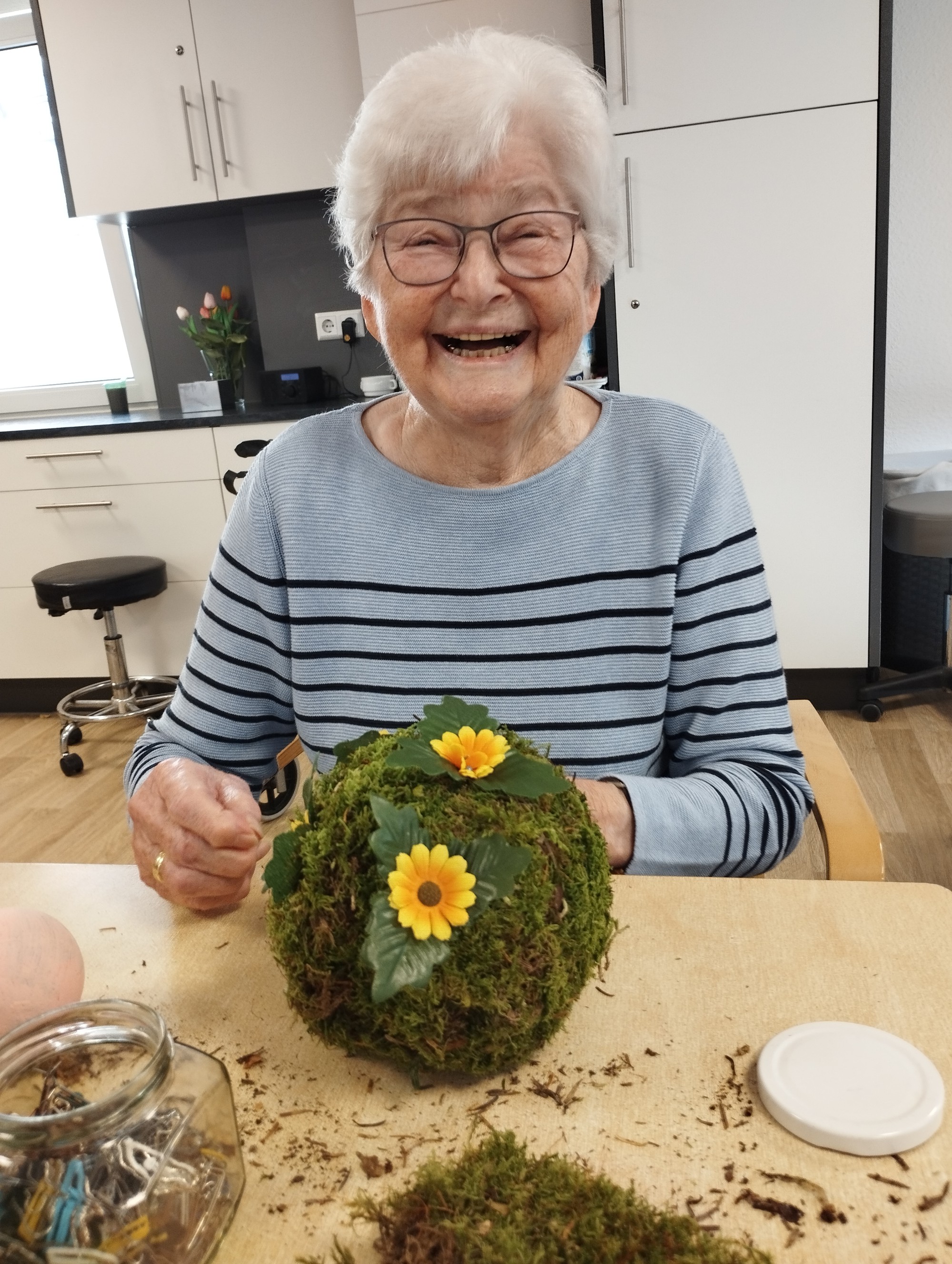 Bewohnerin bindet Osterkranz