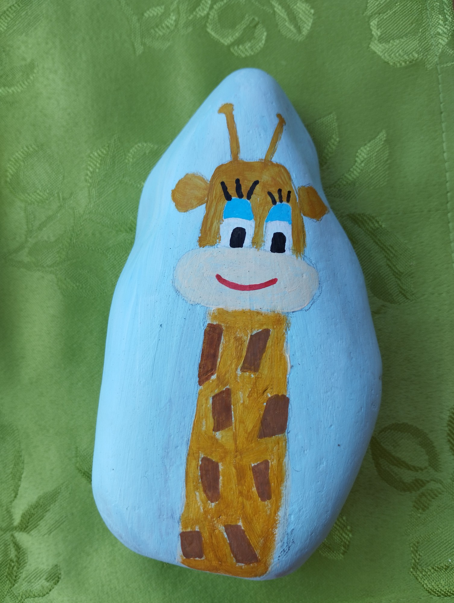 Mit einer Giraffe bemalter Stein