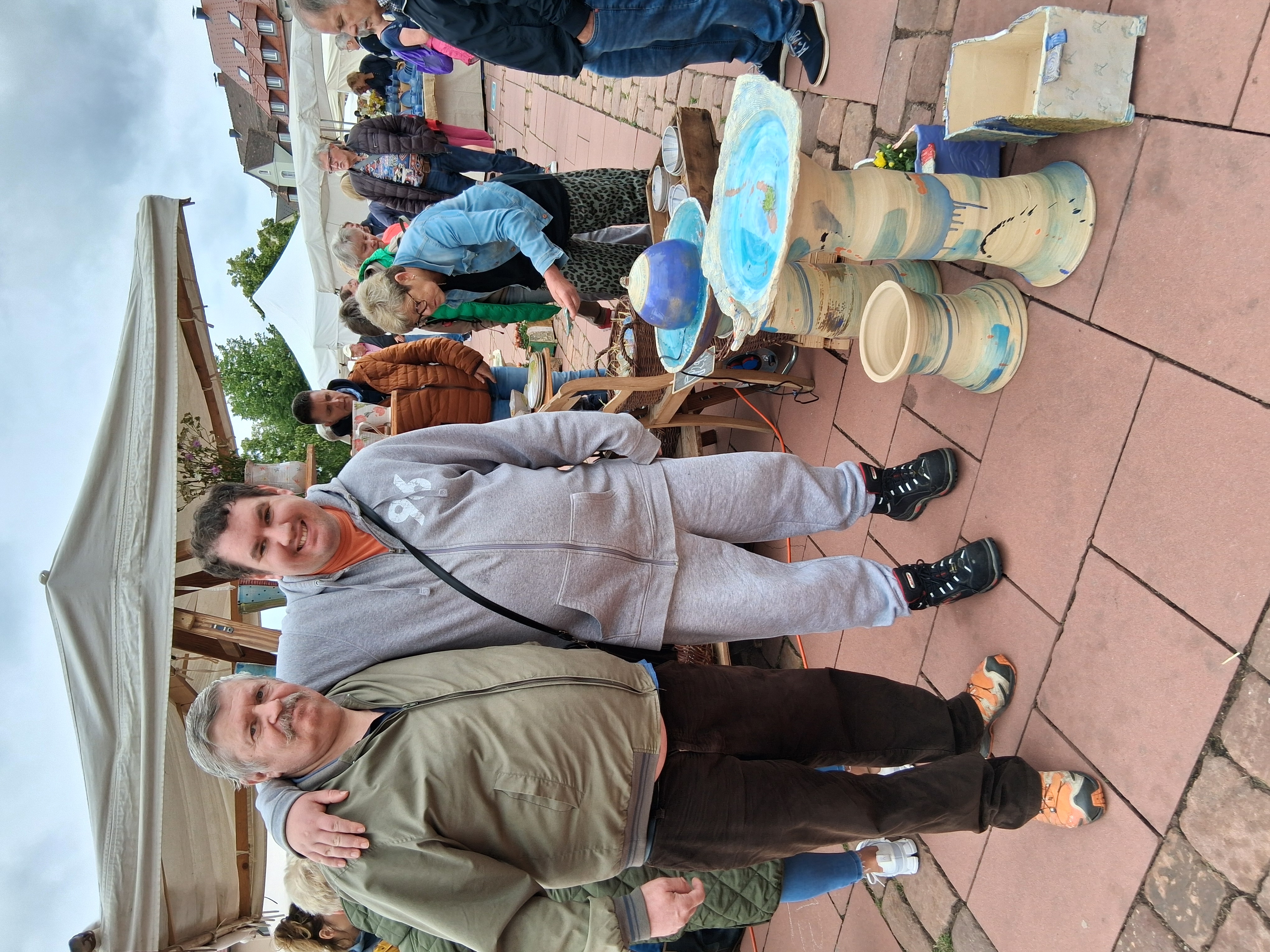 Bewohner an einem Stand des T&ouml;pfermarktes