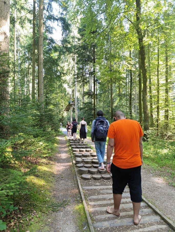 Bewohner/innen laufen den Barfußpfad