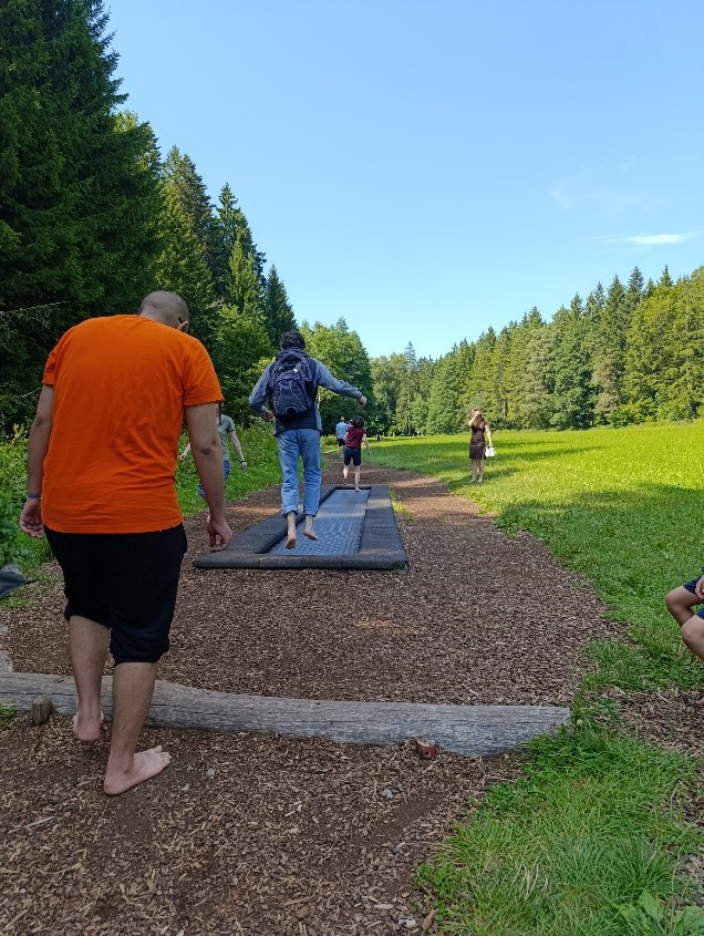 Bewohner/innen laufen den Barfu&szlig;pfad