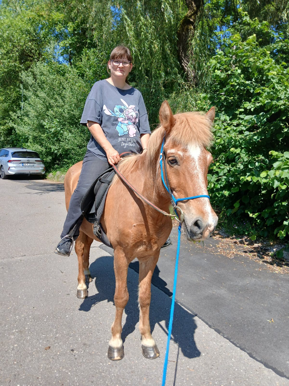 Bewohnerin sitzt auf einem Pferd