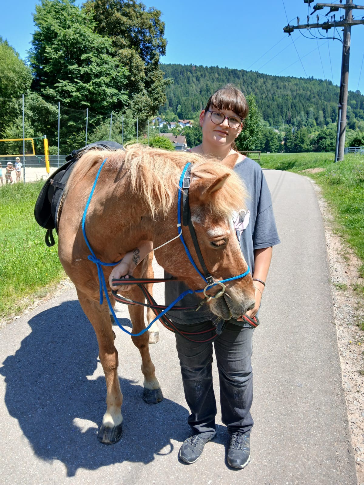 Bewohnerin führt ein Pferd